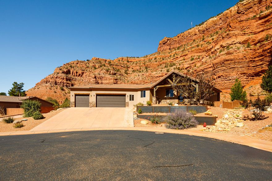 Exquisitely remodeled residence in the beautiful La Estancia community of Kanab. Built in 2018 & thoughtfully reimagined this year, this 3-bedroom, 3-bath estate offers 2,512 sq ft of refined living paired with the awe-inspiring backdrop of Southern Utah's red cliffs. The exterior presents fresh stucco with rich timber accents, a tiered front landscape, & multiple outdoor retreats including a covered patio, open terrace, & intimate fire pit lounge-all framed by the dramatic cliffs rising directly behind the home. Inside, the expansive great room & dining space transition seamlessly to outdoor entertaining. The chef's kitchen features granite surfaces, upgraded appliances, & dual oversized pantries. The primary suite provides private patio access, a designer tiled shower, & an expansive walk-in closet. The finished lower level includes two bedrooms, a full bath, & a spacious family gathering area. A circular drive & 3-car drive-through garage enhance both function & elegance. La Estancia owners enjoy resort-caliber amenities-indoor & outdoor pools, fitness clubhouse, dog park, pickleball court & scenic walking paths. Walking distance to nearby parks& restaurants. Buyer to verify all.
