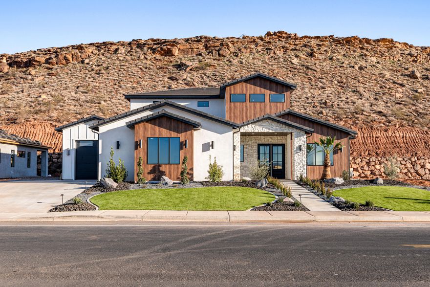 Stunning custom-built home, featuring 5 bedrooms, 3.5 baths, and a dedicated office. The expansive open-concept living room and gorgeous kitchen showcase high-end upgrades throughout. The master bedroom and bath are very spacious & luxurious with a huge walk in closet., all on the main level. This two story home has the perfect family room upstairs, for gathering family and friends.  One of the upstairs bedrooms has its own private bathroom for guests. Enjoy a  4-car garage, concrete coated & RV parking on side of home. Situated on a .67-acre lot, this home offers exceptional privacy with a serene hillside backdrop. Located in one of St. George's most sought-after, family-friendly areas, just minutes from Crimson Cliffs, the newest high school in Washington County. WATER SOFTNER INCLUDED!