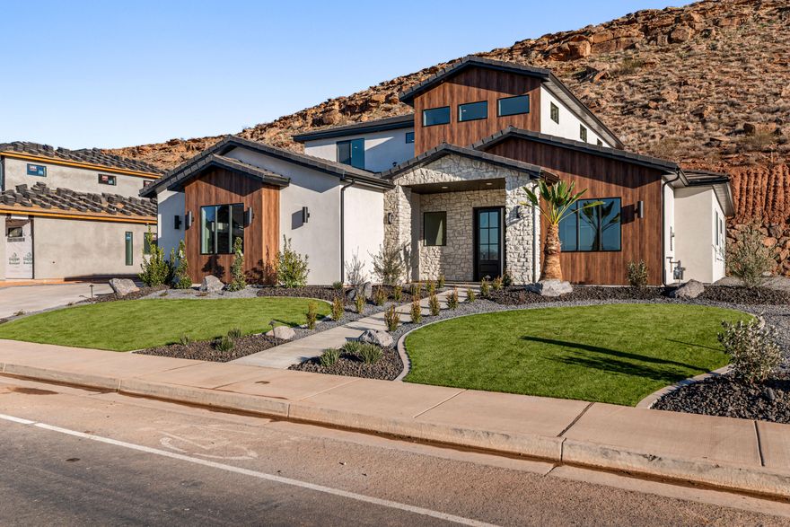 Stunning custom-built home, featuring 5 bedrooms, 3.5 baths, and a dedicated office. The expansive open-concept living room and gorgeous kitchen showcase high-end upgrades throughout. The master bedroom and bath are very spacious & luxurious with a huge walk in closet., all on the main level. This two story home has the perfect family room upstairs, for gathering family and friends.  One of the upstairs bedrooms has its own private bathroom for guests. Enjoy a  4-car garage, concrete coated & RV parking on side of home. Situated on a .67-acre lot, this home offers exceptional privacy with a serene hillside backdrop. Located in one of St. George's most sought-after, family-friendly areas, just minutes from Crimson Cliffs, the newest high school in Washington County. WATER SOFTNER INCLUDED!