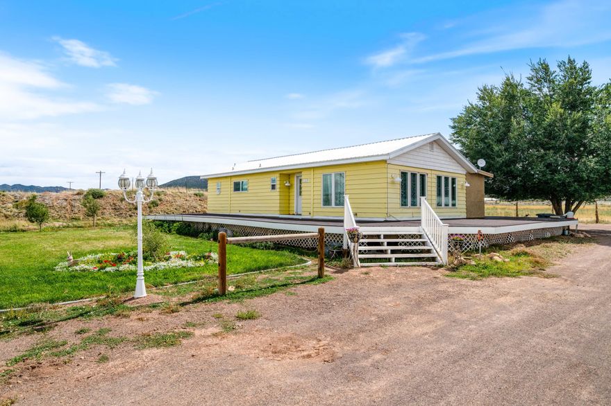 *Acreage, Outbuildings & Possibilities* Set on 2.78 acres, this cute yellow home comes with a full wrap-around porch and plenty of room to spread out. The 25 x 25 metal garage offers solid storage or workspace, and the 42 x 41 barn is equipped with power and water, ready for projects, animals, or hobbies. Inside, you'll find a straightforward layout with two bonus rooms at the back for storage or office use, plus charming built-ins in the dining area. With its land, outbuildings, and potential, this property is a rare find and presents a wonderful opportunity to bring your vision and style to life.