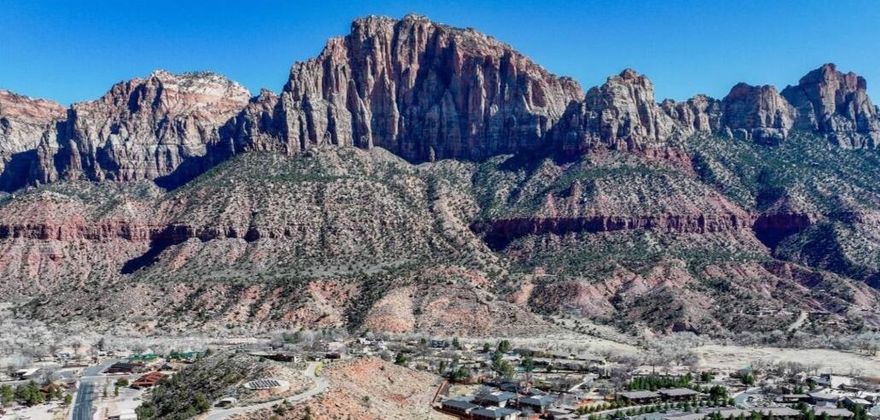 The Zion Retreat you've been looking for! Nestled in the tranquil Moenave community, just half a mile from the entrance of Zion National Park, this stunning home offers breathtaking, unobstructed views of The Watchman and West Temple mountains.
With expansive windows and 9' ceilings natural light fills every corner, ensuring you're surrounded by breathtaking scenery from every room.
The thoughtfully designed floor plan provides an inviting and spacious living area. The kitchen features a large island, granite countertops, subway tile backsplash, and custom cabinetry with crown molding, glass accents, and under-cabinet lighting. Stainless steel appliances, including a gas (propane) range and side-by-side refrigerator with water and ice dispenser, complete the space. The covered patio off the dining area creates a tranquil outdoor living space.
Luxury vinyl flooring flows throughout the main living areas, complemented by recessed lighting. Bathrooms feature tile flooring, tile shower surrounds with glass doors, and granite countertops, adding to the home's refined design. 
This home is like brand new, having only been stayed in for 2 or 3 weekends. All furnishings are available for purchase, making a seamless transition into your move-in-ready retreat.
Built with high-quality, energy-efficient features, including 2x6 exterior walls, blown-in insulation (R50 attic / R23-25 walls), Low-E windows, a 95+% efficient furnace, and a tankless water heater, this home offers both comfort and sustainability.
Located at the heart of Springdale, and in walking distance from its shops and restaurants with an abundance of stunning hiking and biking option, this home is the perfect blend of luxury, convenience, and breathtaking, natural beauty. Everything you dreamed your Zion Retreat would be, and more!
Springdale does not allow overnight rentals. Long term rentals are allowed at a minimum of 60 days. All information provided as a courtesy. Buyer to verify all.