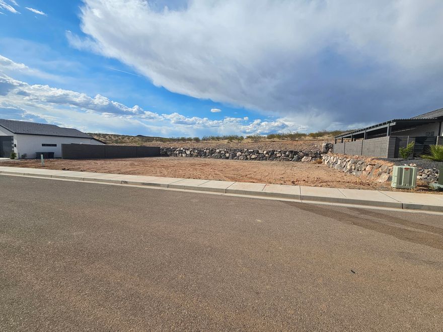 Don't miss out on this fantastic home site!  Grand Heights is the perfect place to build your dream home.  The property backs up to the Red Cliffs Desert Reserve.  Enjoy the recreation right out your back door!  Three minutes from the freeway and shopping.  NO HOA!!!  Owner contractor will help you design and build your custom home, or bring your own builder.  WATER FEES HAVE BEEN PAID ($13,500 savings to buyer)  Recent block wall was built.