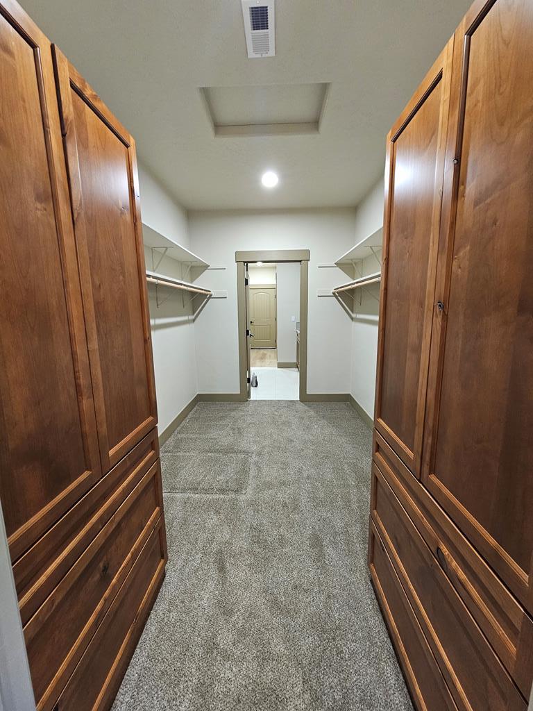 Walk in closet with storage., Large alder cabinets on both sides with drawers as well.
