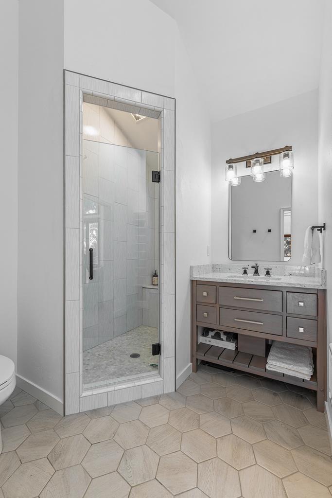 Primary bathroom., Hexagon floor tiles, tiled shower walls and pebbled tile floors.