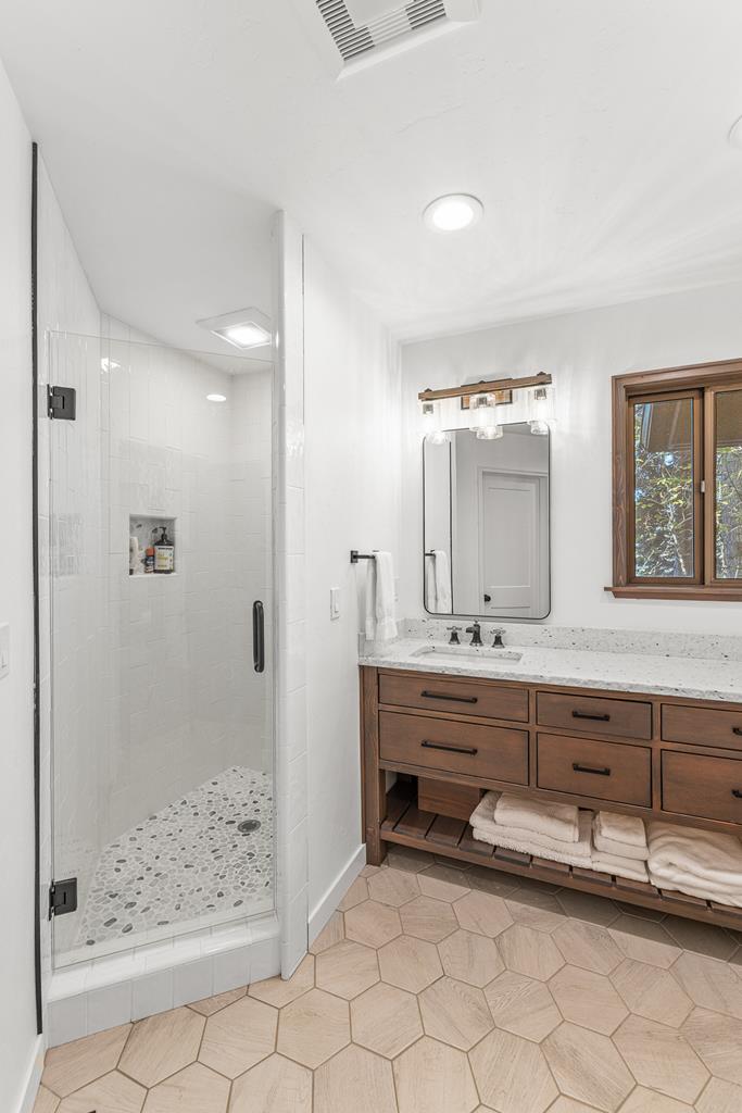 Downstairs bathroom., Hexagon floor tiles. Walk in shower has custom subway tiles with a pebbled tile floor.