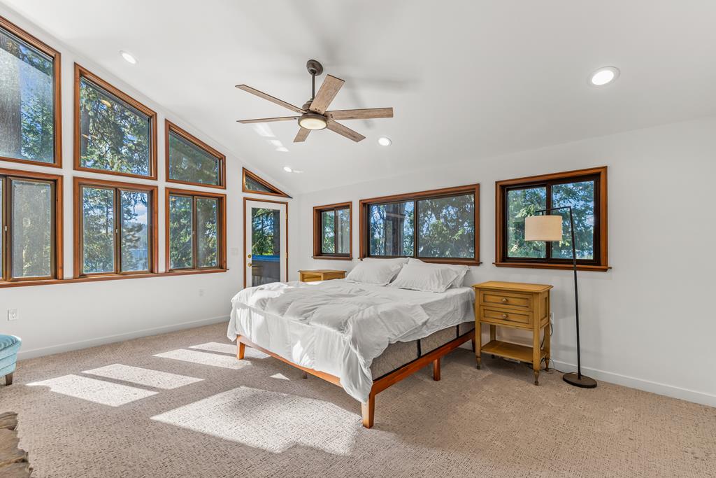Primary bedroom., Yet another wall of windows framing the lake views and the surrounding pines.