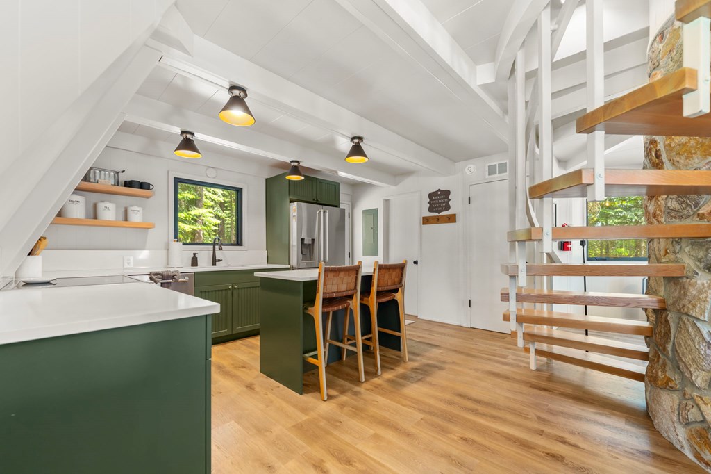 The Kitchen Bar, The remodeled kitchen boasts an induction range, open shelving and custom cabinetry.