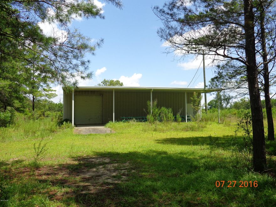 CRYSTAL LAKE cabin/warehouse on 1 acre. Enjoy the lake view from the covered porch. Comes with a full bath and kitchen with the rest to finish and use as you wish. There is 400 AMP electric service here with Air Compressor piping in place, peg board, insulating, lots of over head lighting and a roll up garage door. Provisions for Motor Home parking with the acre lot completely fenced. Building is approximately 30x50.