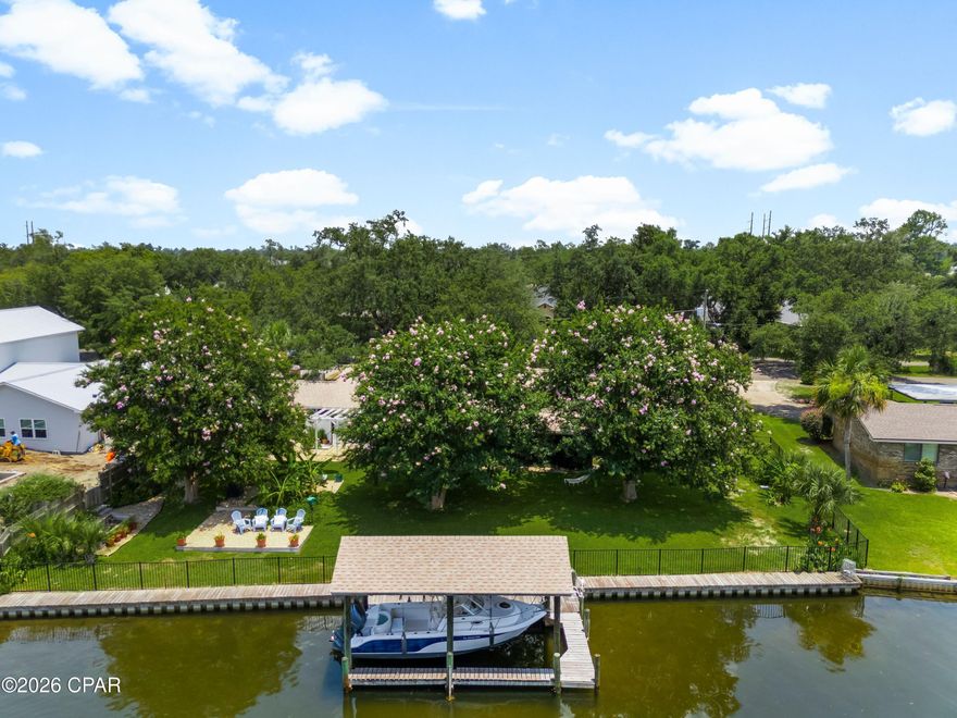 Positioned along a deep-water canal on a quiet dead-end, oak-canopied street, 4439 Vista Lane offers a relaxed waterfront setting designed for both everyday comfort and life on the water. Located in the desirable Northshore area of Lynn Haven, free from HOA restrictions, this three-bedroom, two-bath residence spans approximately 2,505 square feet and offers generous interior living space with direct boating access. The home's canal frontage is a defining feature, allowing you to step outside and head straight onto the water. A seawall replaced in 2022 and boat lift motors newly installed in 2025 within a covered boathouse enhance the property's functionality, making it easy to launch a boat and spend the day exploring the surrounding waterways, cruising toward Shell Island, or venturing out into the Gulf. The peaceful canal setting also creates an inviting backdrop for outdoor relaxation, whether enjoying morning coffee by the water or unwinding in the evening with a coastal breeze. A fully fenced backyard adds both privacy and practicality, ideal for pets, gatherings, or simply enjoying the outdoor space. Inside, the residence offers a spacious layout with flexible living areas suited for both quiet evenings and lively gatherings. Multiple living spaces allow for comfortable day-to-day living while providing room to entertain family and friends. Large windows invite natural light throughout the interior, reinforcing the home's open and airy atmosphere. Several major system improvements add long-term confidence for the next owner. The roof and windows were replaced in 2019, while essential infrastructure, including the septic tank, drain field, lift station, and well, was updated in 2016. These thoughtful updates enhance the home's functionality and durability while supporting a low-maintenance waterfront lifestyle. The property's location further enhances its appeal. Set within the established Northshore area of Lynn Haven, the home enjoys a sense of privacy while remaining close to everyday conveniences, top-ranking schools, local dining, and shopping. Lynn Haven itself is one of the most sought-after residential communities in Bay County, valued for its strong sense of community, parks, and access to the water. From this location, residents are just a short drive from the white sand beaches of Panama City Beach while still enjoying the quieter pace of a residential coastal town. With nearby marinas, boat ramps, restaurants, and retail centers, the area offers an ideal balance between waterfront recreation and everyday convenience.