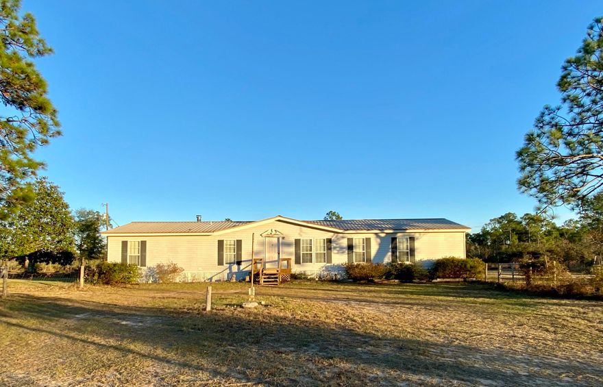 Over 13 and a half fenced acres with a separate entertaining room currently set up as a bar, a spacious 4 bed double-wide, and much more! Features include: a sunroom, sitting room in the master, an above ground pool, large back deck with a hot tub, propane centurion generator, gazebo, greenhouse, 20x12 storage shed w/loft, 48x50 garage/workshop/utility room/'bar', 25x18 metal detached carport, 24x20 bldg., and second well/septic. Placed here brand new in 2005 along with the main well and septic, the home has only a 6 year old roof. The 48x50 building behind the home is on a slab and has a new roof. It is a garage/workshop on one side and an entertaining space on the other. The side used for entertaining is currently set up as a bar. There is a bar top with a back bar, a pool table, and a tv hookup. Beyond the bar is the utility room with a kitchen, water heater, large deep freezer, and bathroom. The garage is equipped with cabinets and tool storage. The workshop is equipped with shelving. Behind the workshop there is a washing machine and outdoor shower for cleaning up after a long day working on things. On the back corner of the property there is a 24x20 building with walls, a slab, and its own well/septic. All of this is situated on a paved road out in the country. If you're looking for privacy, space, and a place to relax and have fun that already has it all look no further!