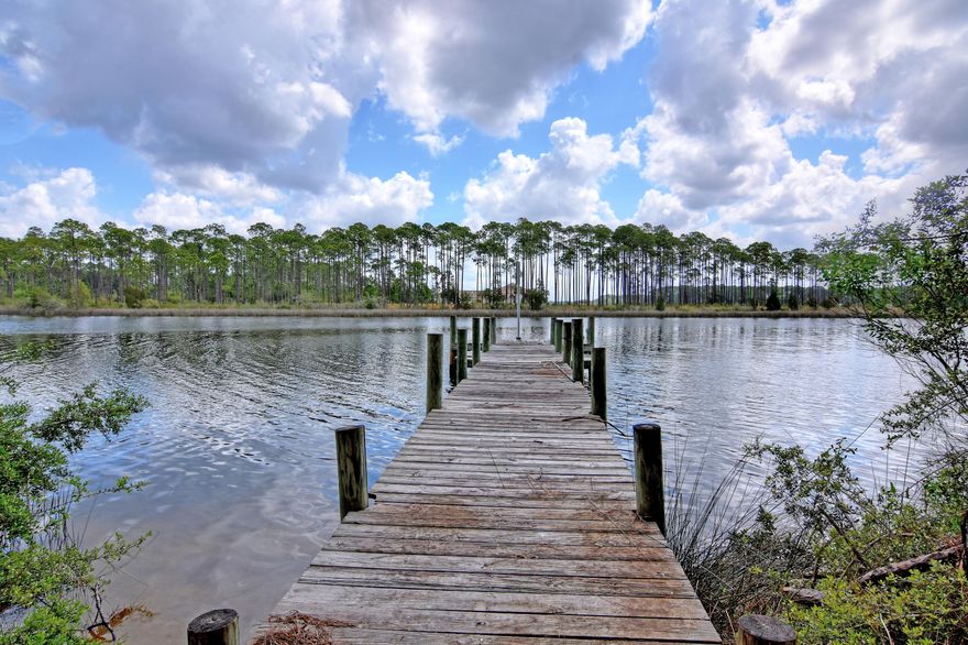 REDUCED 20k BELOW CURRENT APPRAISAL! 

WATERFRONT Living with 2.47 ACRES of privacy and approx. 325 ft of waterfront property.   Enjoy your own boat dock with access to St. Andrews Bay and Gulf.  After your day of fishing, enjoy your private screened swimming pool for relaxing.  This home has a large kitchen with tons of cabinets and counter space.  Solid surface counter tops with an island.  The large living room has vaulted ceilings and views of your pool and the bayou.  The large master bedroom offers ample closet space and a private bath.  This home offers a bonus room over the garage with a deck and private entrance.  There is a large workshop on the property with double garage doors and storage above the shop.  Another out building exists with a covered area as well.