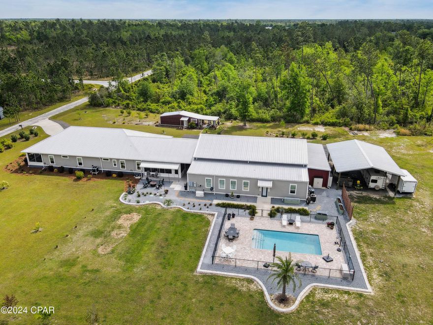 UNDER CONTRACT- ACCEPTING BACK UP OFFERS - COASTAL DREAM ESTATE WITH RESORT-STYLE AMENITIES - JUST 20 MINUTES FROM MEXICO BEACH! Experience the perfect blend of luxury, comfort, and coastal living in this exceptional estate nestled on nearly 9 acres in Wewahitchka, FL - just 20 minutes from Mexico Beach and 25 minutes from Port St. Joe.  This custom home offers a resort lifestyle. Enjoy the coastal life without the salt air maintenance that comes with living right on the coast.  Embrace the peace, privacy (dead-end road), and versatility this property provides.  Designed for seamless relaxation, entertainment, and multigenerational living, this exceptional property combines the comforts of modern living with the beauty and space of a private estate.  The main residence offers 2,600 sq ft of elegant living space with 3 bedrooms and 2 baths, featuring smart home technology, large mud room and laundry room, screened front and back porches,  and a whole home generator for ultimate peace of mind. A separate 1,000 sq ft private guest bungalow - complete with full kitchen, bedroom, bath, and living area makes the perfect private suite for extended family, guests, or independent multigenerational living.  Outdoors, indulge in resort-style amenities with lush landscaping and lighting including a 28'x14' inground heated & chilled saltwater pool- perfect for outdoor entertaining.  For car enthusiasts there is a 40'x60' luxury 6 car garage/workshop-heated and cooled, a 400 sq ft loft office wired for tv/internet, a 28'x14' air conditioned she-shed, and a 30'x40' pole barn.  ADDITIONAL HIGHLIGHTS INCLUDE: climate-controlled 10'x10' pet suite with automatic door & Invisible Fence, climate controlled 28'x12' storage room with laundry hookups for the bungalow, 30'x12' outdoor storage room attached to main garage, app-controlled irrigation, underground rainwater drainage, Ring security system, app-controlled irrigated raised garden beds, and a carport for two cars.  Beach days within reach-without the salt air wear-and-tear.  This is more than a home - it is a DESTINATION built for family, freedom, and the future.  Must see in person - pictures do not do this place justice!