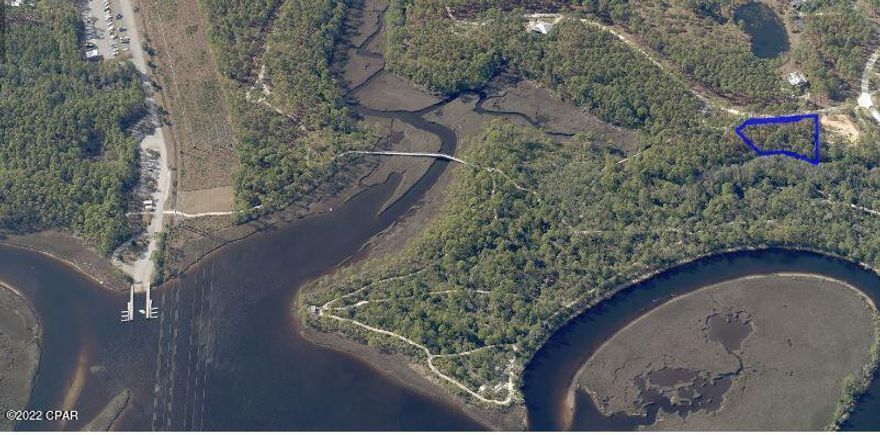 Situated in the exclusive, gated community of RiverCamps is this gorgeous 3/4 acre wooded Lot with a large buildable area that backs to the conservation area with no neighbors behind, ever. RiverCamps is a 1500 acre oasis surrounded by West Bay, the Intracoastal waterway and Crooked Creek and will have less than 450 homes on 500 acres with the remaining 1000 acres committed to conservation. Enjoy 7 miles of trails, world-class amenities including a community boat ramp, day-use boat slips, zero-entry pool, fitness center, unlimited use of kayaks, canoes, paddleboards and bicycles. Ideally situated by the Northwest Florida airport and only 10 miles from Pier Park and the beautiful white sand beaches and the Gulf of Mexico.