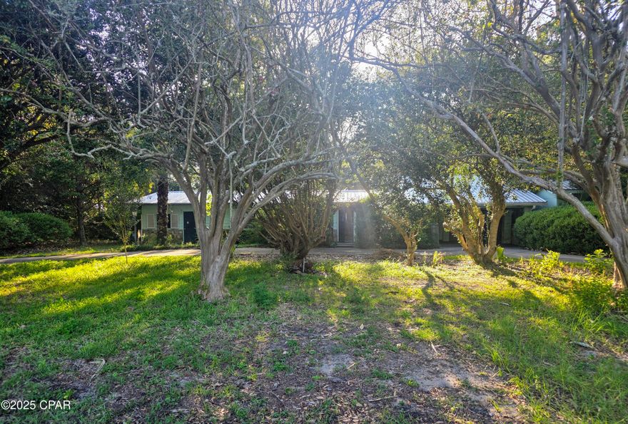 Discover an unparalleled RARE opportunity! Nestled on a generous 0.562-acres this unique property caters to both visionary builders and those dreaming of a vast, private homestead. The 1,836 sq ft original homestead was tailored for versatility and spacious living, with 3 bedrooms, 2 bathrooms. Additional rooms offer flexibility to be used as office area/ bedrooms.  Character and warmth pervade the home, notably through two gas fireplaces and the Wood paneling throughout that add a cozy ambiance to the living spaces. Right off the kitchen walk out in the 15 x 15 Sunroom to enjoy the serene view. Take note of the presence of updated windows coupled with hurricane shutters, new metal roof in 2019 and a Generac generator that ensures year-round safety and comfort, safeguarding against the elements.  The property is also equipped with numerous metal-roofed storage sheds (14x14, 12x10, 14x12 with electric) and enhancing its functionality and appeal as a true hidden treasure.  Located mere minutes from the bustling Pier Park, known for its vibrant dining, entertainment, and shopping, and close to the idyllic 30A and Frank Brown Park, this property promises a lifestyle of ease and enjoyment. The neighborhood is golf cart-friendly, near an array of shops and restaurants, and offers proximity to the Gulf of Mexico's exquisite sugar-white sands. With no HOA to limit your vision, this property stands as a versatile canvas for creating a grand homestead or embarking on a lucrative development project, capturing the essence of serene living and remarkable potential in Panama City Beach.