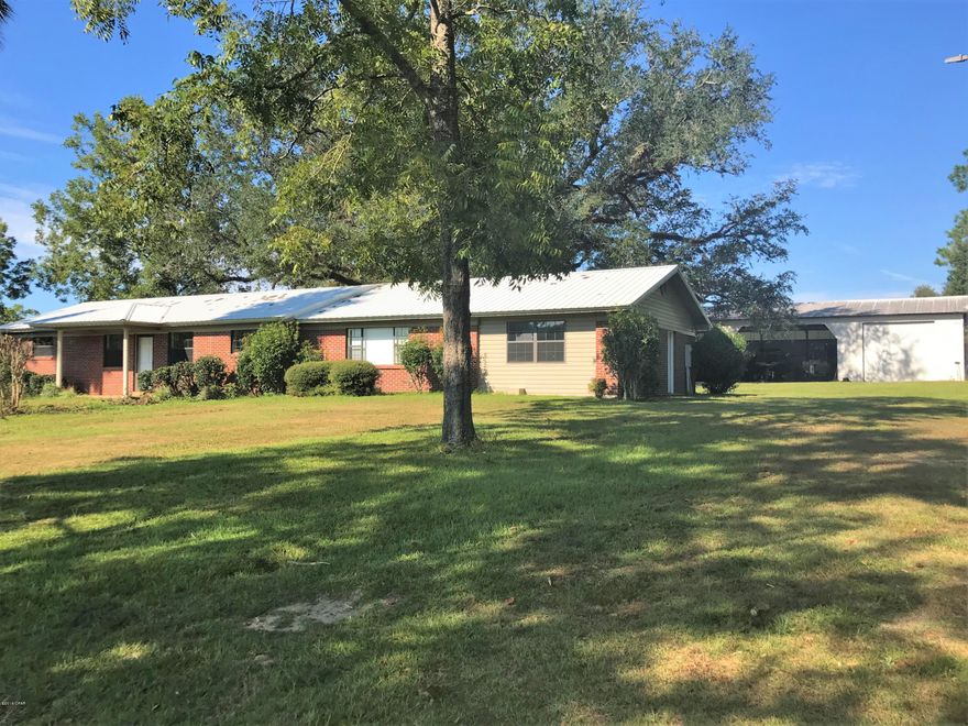 Enjoy the privacy and view of over 50 acres and only having to maintain 1 acre!! This very large home sits between Grand Ridge and Sneads in a rural area not far from town, Three Rivers State Park and Apalachicola River. Just a couple of miles from a boat ramp. Inside is a split floor plan, with 4 bedrooms, one that would make a great office, huge laundry room and pantry, a lot of storage, satellite in every room, tons of cabinets space in the kitchen, double pane windows, AC is approx 6 years old, roof was put on March 2018 and a new hot water heater. Outside is a 40x48 pole barn with an attached 24x40 workshop that has a roll up door, 14x16, electricity, plumbing and a concrete floor. Approximately $60,000 value. Right out the back door is a fully screened in cook house!! Come see!