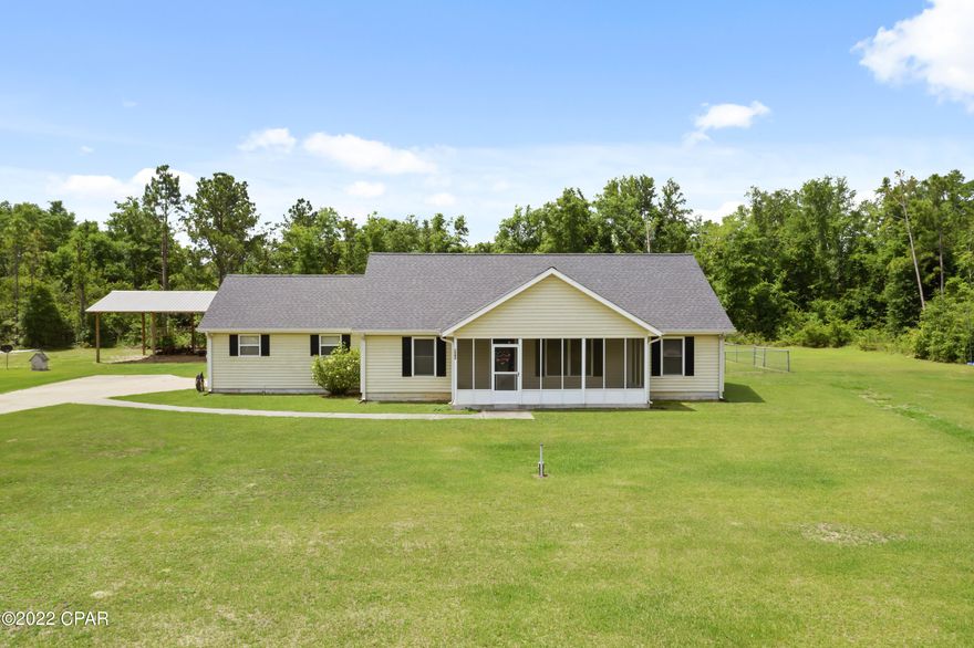 This three bedroom home has the feeling of country life, but is located near a highway that allows for quick access to Panama City.  Outside you will find a 24x36 pole barn and a fenced in back yard.  Well features a filtration system.  Roof was replaced in 2019 and a new hot water heater was installed in 2022.  Home has a nice sized screened front and back porch.  Kitchen has nice island, some updated appliance, and plenty of cabinets for storage.  The home features a split bedroom floor plan.