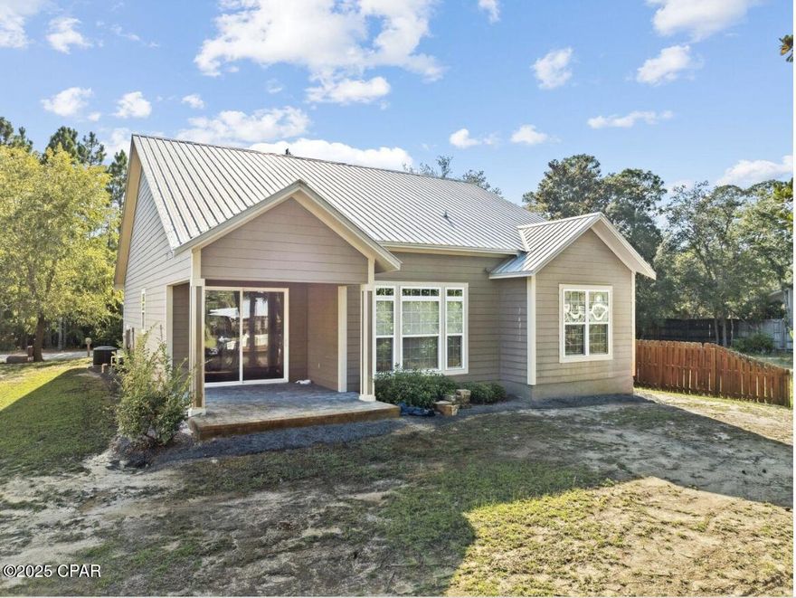 A tranquil waterfront setting and thoughtful design make this one-level Florida Cottage an inviting coastal retreat. This three-bedroom, two-bath home sits gracefully along 69 feet of serene canal frontage, complete with a private dock where you can relax with canal views or launch your paddle-board for a day on the water. Inside, the open-concept floor plan frames the canal scenery from the living, dining, and kitchen areas, complemented by soaring ceilings and recessed lighting for an airy feel. Tile floors flow throughout, blending style with easy maintenance. The kitchen features granite countertops, stainless steel appliances, generous cabinetry, and a casual elegance ideal for everyday living or entertaining.