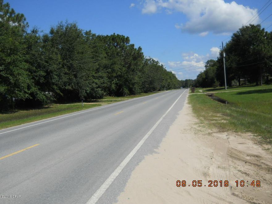 Reduced!  Motivated seller!  Make offer!  One full acre directly on paved Hwy. 2301.  Property has a older mobile home that has been destroyed by hurricane Michael.  No value given to the structure.  Property is cleared and has well, septic, and power that is not warranted by the seller.   Two power poles on property.  The other has most recently been used for an RV.  Possible owner finance with $6,500 down. 8.5% for 10 years.
