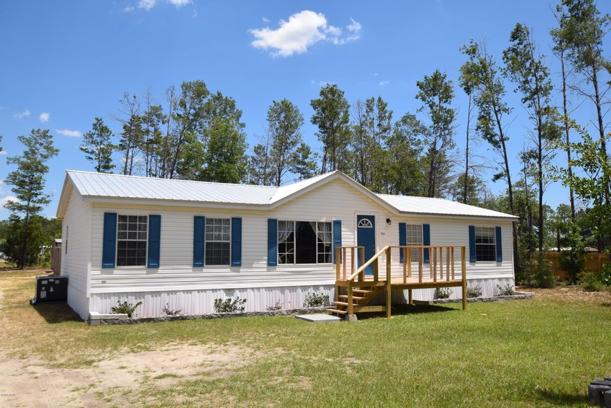 Immaculate double wide mobile home on .86 acres! This home is located in the White Western Springs subdivision which features underground phone, power, cable tv, and only 15 minutes to town.  The well tank and pump are new.  New metal roof.  New front porch. The huge lot borders two paved roads, White Western Springs Rd in the front and Moon Court in the back, and has a large section privacy fenced for pets or children to play outside. The home features fresh paint, vinyl plank flooring through out, split bedrooms, and a huge laundry room. The HVAC is only 2 years old. This is priced to sell and will not last long!