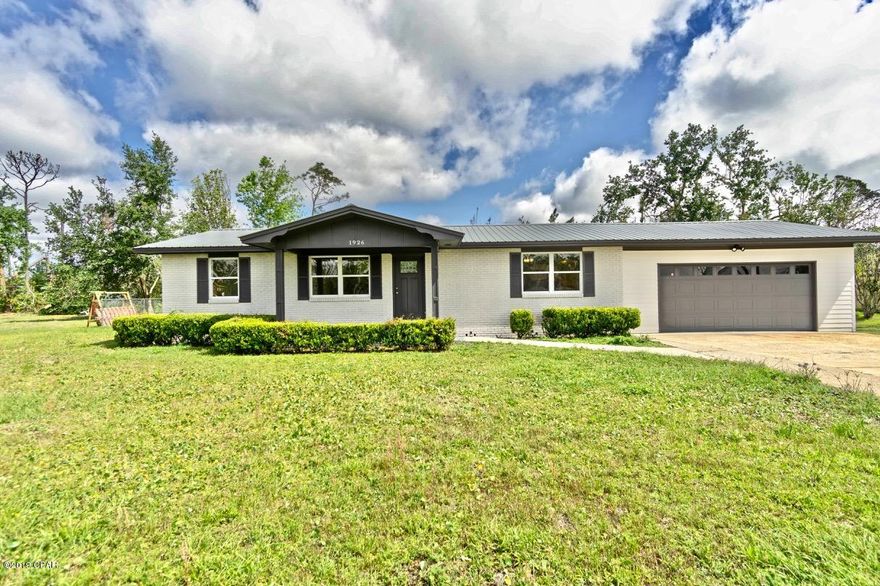 Move In Ready with 3/4 acre lot on paved road in town!!! Lovely remodeled brick home with metal roof. Lots of new, new, new, including windows, HVAC, kitchen cabinets, granite counter tops, stainless appliances, flooring, vanities, faucets, light fixtures, interior & exterior paint, etc. Beautiful, calming, modern color scheme. Large family room is pad ready for a wood burning stove. HUGE laundry/utility room. Keep ironing board, steamer, clothes rack, etc. setup up and ready at all times! HUGE backyard. Oversize garage, with separate storage room,  lots of parking.  In town but just outside the city limits in unincorporated Bay County so I think you could even have a horse! Think septic system was replaced June 2015.