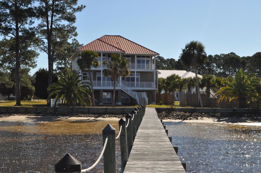 Completely remodeled! Amazing views from this Lynn Haven home. This 5BR/4BA residence comes with a boat dock making it the perfect home for aquatic adventurers! Hardwood floors, transom windows, a fireplace, crown molding; those are just a few of the highlights. Then the sellers took this already amazing home and kicked it up a notch with a brand new kitchen featuring exotic granite countertops, stainless appliances and all new cabinets.  The carpet is brand new in all 5 bedrooms, new closet doors installed, and freshly painted walls and trim too!  The Master suite is on the 3rd floor with an adjoining office, a corner fireplace and the en suite has double vanities, a new whirlpool tub,walk-in shower, and a huge closet with laundry chute. Did we mention there are balconies off the 2nd and 3rd floors?   And on the first floor, along with the oversized two car garage, there is a huge bonus area with break-away walls that would make a fantastic workshop/home gym/rec room.  This is a home you need to see to believe and it's move-in ready!  The roof is metal, the AC and waters heaters are new, and it's all electric.   You're a block from a playground and picnic area and only 5 minutes from schools and shopping.   Sit on your deck and/or dock and have front row seats to the fireworks show every 4th of July and the beautiful sunsets over the bay all year long!  All info is approx. and must be verified by Buyers if important.