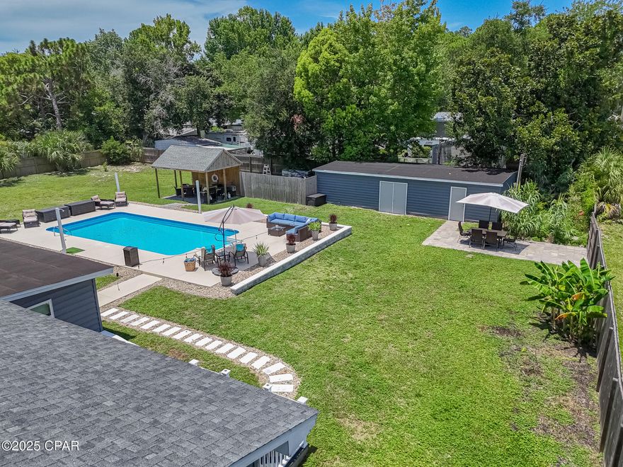 Beach living with less rules and more flexibility (no HOA)! Looking for an updated, single story home with impact windows on over 1/2 acre, close to the beach and move-in or rental ready? Keep reading! No Homeowner Association (HOA), a 20,000 gallon saltwater pool with Glacier cooler to keep you swimming all Summer (with brand new liner!), tankless hot water heater for those long hot showers, and plenty of room to park your boat or RV, this home is a Panama City Beach oasis!  Less rules, more flexibility (no HOA)! There is even enough space for a pickleball court! Included in the property is a 1BR/1BA In-law suite with full kitchen attached to the home with its own entrance, and a massive 800 sqft detached storage building. The backyard is both your private sanctuary and an entertainer's delight with its own grilling pavilion, plenty of room to lounge by the pool, or set up cornhole or a volleyball net for a BBQ with family and friends. A 2nd power pole also services the property and is ready to install your Tesla or RV charging station, or build your own invention, dream, or addition!