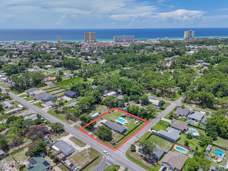 Beach living with less rules and more flexibility (no HOA)! Looking for an updated, single story home with impact windows on over 1/2 acre, close to the beach and move-in or rental ready? Keep reading! No Homeowner Association (HOA), a 20,000 gallon saltwater pool with Glacier cooler to keep you swimming all Summer (with brand new liner!), tankless hot water heater for those long hot showers, and plenty of room to park your boat or RV, this home is a Panama City Beach oasis!  Less rules, more flexibility (no HOA)! There is even enough space for a pickleball court! Included in the property is a 1BR/1BA In-law suite with full kitchen attached to the home with its own entrance, and a massive 800 sqft detached storage building. The backyard is both your private sanctuary and an entertainer's delight with its own grilling pavilion, plenty of room to lounge by the pool, or set up cornhole or a volleyball net for a BBQ with family and friends. A 2nd power pole also services the property and is ready to install your Tesla or RV charging station, or build your own invention, dream, or addition!