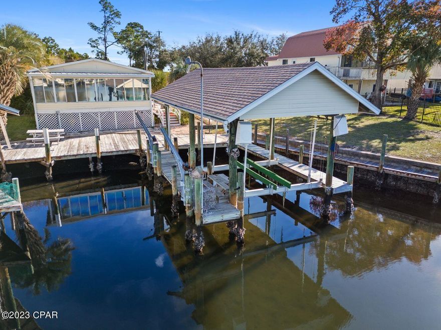 Discover your ideal waterfront retreat for boating and fishing enthusiasts! This 2-bedroom, 2-bathroom home provides deep water access and a spacious open floor plan. The 28' boat house, equipped with boat and jet ski lifts, ensures swift water access, whether you're headed to Shell Island or the Gulf for a day of adventure.

From your back deck, witness dolphins playing or try your hand at redfish, utilizing the convenient cleaning station. Relish year-round sunsets in the heated and cooled Florida room. The 20x10 workshop, paired with the boat house, completes this waterfront home, offering a perfect spot to unwind and enjoy the scenery.

With its myriad features, this waterfront haven is the complete package. Contact your agent to schedule a viewing today!
