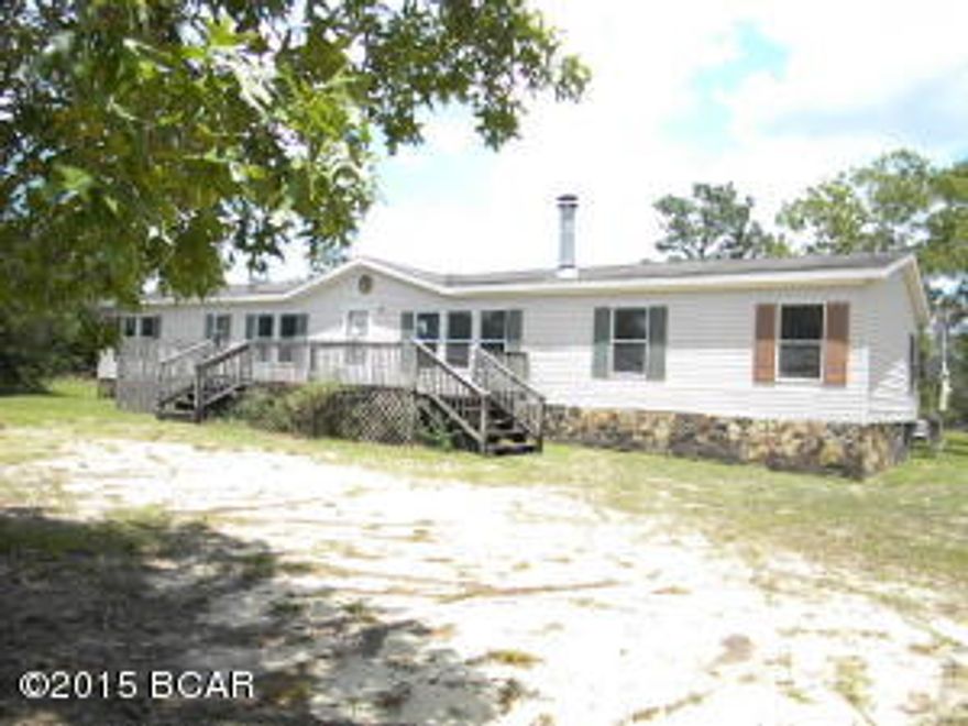 Large 1976 sq ft doublewide with 4 bedrooms on 3 acres, just off of paved HWY 20, living room with fireplace, large den with built ins, front and rear decks, needs some personal touches for you to call this home.