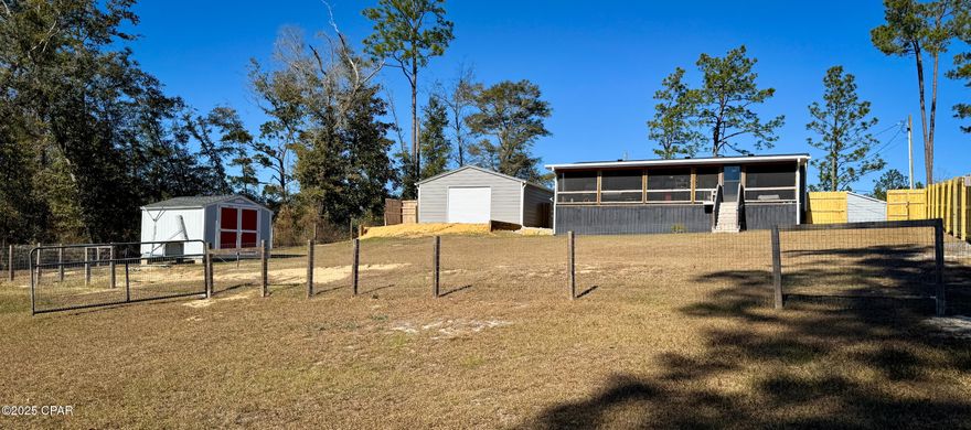 WATERFRONT home on COMPASS LAKE!!!  Comes with a 2021 Doublewide Mobile 3/2 home that looks like new. 2 car carport measuring 26x35,  Take an afternoon nap on the bed swing on the large screened in porch over looking the lake.  Fenced in lakeside yard with privacy fence. Dock with Aqua Thruster ($3500 value) to keep vegetation cleaned out from around the dock.  On Compass Lake you can fish, swim, Ski, cruise, Jet ski etc. 16 x16 pump house with ample storage space, paved road frontage. Home can be used as an Air B&B for extra income.  What a getaway place. 2 restaurants close by. Relax and Relax some more. RV Electrical hookup with water. 35 minutes from Panama City Fl. 12 minutes to I-10. MOTIVATED SELLER!