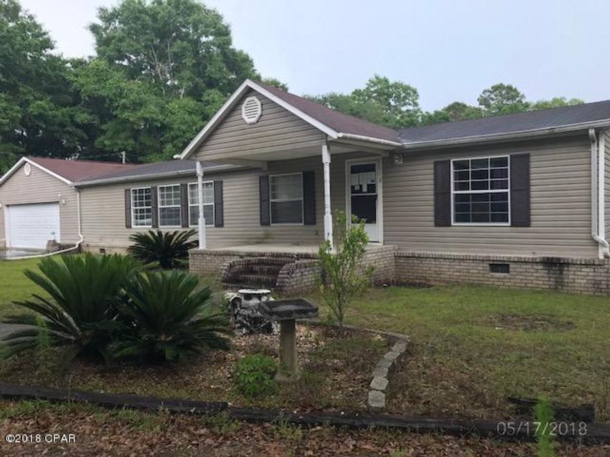 Three bedroom, two bath home on 5 acres with frontage on Hwy 90.  Attached two car garage.  Home sits on 5 acres off highway 90 at end of paved drive.  Large oak and several sago palms in front yard.  Private well and septic.  Total electric.  Kitchen island with sink. Microwave and dishwasher in kitchen. MBR has large walk in closet. Master bath has garden tub and shower. Covered front porch. Brick under skirting on front, shingled roof, open deck on back.  Tile in kitchen cracked.