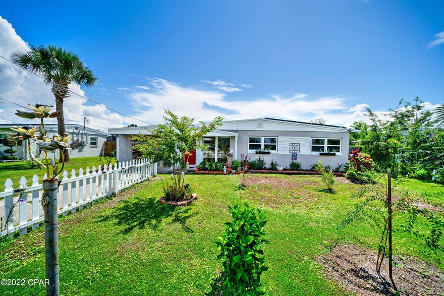 CURRENTLY UNDER CONTRACT, SELLER WILL CONSIDER BACKUP OFFERS This beautiful 3 bedroom, 2 bathroom home is located in the desirable community of Lynn Haven. This home welcomes with a gorgeous fenced in front lawn with beautiful flowerbeds and foliage throughout. To the side of the award-winning lawn is a covered carport with a swing as well as access to the laundry room. The privacy fence features a gate on either side of the home and a double gate at the back, directly off the alleyway to access the huge backyard. This home boasts solar panels to reduce the electric bill. This home greets with a spacious dining area adorned with large windows, boasting a perfect view of the front garden. The kitchen is equipped with white appliances, lots of counterspace, plenty of cabinets for storage. Off the kitchen is the spacious living room that's perfect for entertaining, featuring plenty of windows to allow for natural lighting. Off of the living room there is a bar to relax and unwind featuring access to the backyard. The primary bedroom features a sitting/flex room that would be perfect for an office or game room, as well as a private en suite bathroom featuring a shower/tub combo. There are two additional bedrooms that share a full guest bathroom that also features a shower/tub combo and a large vanity with lots of storage. The backyard offers plenty of space to enjoy the Florida sunshine with family and friends. This home is located near many parks including dog parks, splash pads and waterfront parks with public boat ramps. This home is also located near schools, restaurants, shopping and more! The community of Lynn Haven hosts many free seasonal activities including parades festivals and outdoor movie nights! Check out this home today!