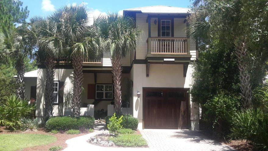 Charming Old Florida style Martinique home with lake-view and a courtyard entrance. The interior features a large island kitchen open to living and dining rooms with stainless steel appliances, granite counter tops, custom cabinets,tile floors and a walk-in pantry. The living space has hardwood floors, a breakfast bar open to the kitchen and a separate dining room. The large covered porch wraps the living room with two sets of French doors.  Upstairs you will find a large master suite with a private balcony, a master bath with double vanities, a garden tub, large tiled shower, and a walk in closet.  There are two additional bedrooms, a bunk hall, another full size bath, and two additional balconies.