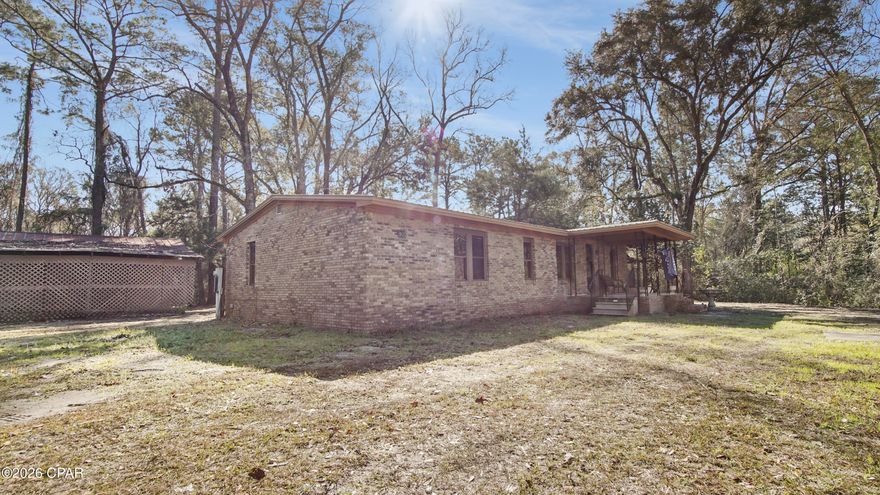 Privacy, space, and nature come together on nearly 4 acres, just a short walk from the Choctawhatchee River in this beautifully updated brick home. The home has received significant updates, including new ceilings, updated flooring, and thoughtfully renovated kitchen and bathrooms. The kitchen features newer stainless steel appliances and a spacious island with additional seating. 

A warm wood-burning fireplace welcomes you as you enter, while the expansive sunroom showcases large windows that flood the space with natural light and bring the outdoors in. The bedrooms are generously sized and offer excellent storage throughout.
Outside, you'll find a large outbuilding with endless potential for a workshop, RV/boat storage, or hobbies, along with a covered front-yard carport.

 Additional features include a metal roof, private well and septic system, and natural gas. With unmatched privacy and wide-open land, this property is truly a dream for those seeking space and tranquility.