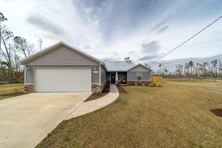 Looking for a lot of land with an almost new home? Here it is! This home site is almost 1-1/3 acres with a separate workshop / storage building. The area is quiet, yet offers convenient access to everything Panama City has to offer. A huge privacy fenced yard could be expanded to include the remainder of the back land. The large eat-in kitchen has stainless appliances, a pantry and granite countertops. It's open to the large family room with a tray ceiling. The master retreat has a tray ceiling, walk-in closet, and spa-inspired bath with dual granite vanity and large tile shower with frameless glass surround. Entertain inside with the open plan or outside on the covered patio. This home offers both curb appeal and energy efficiency with craftsman style, stone accents and a metal roof.