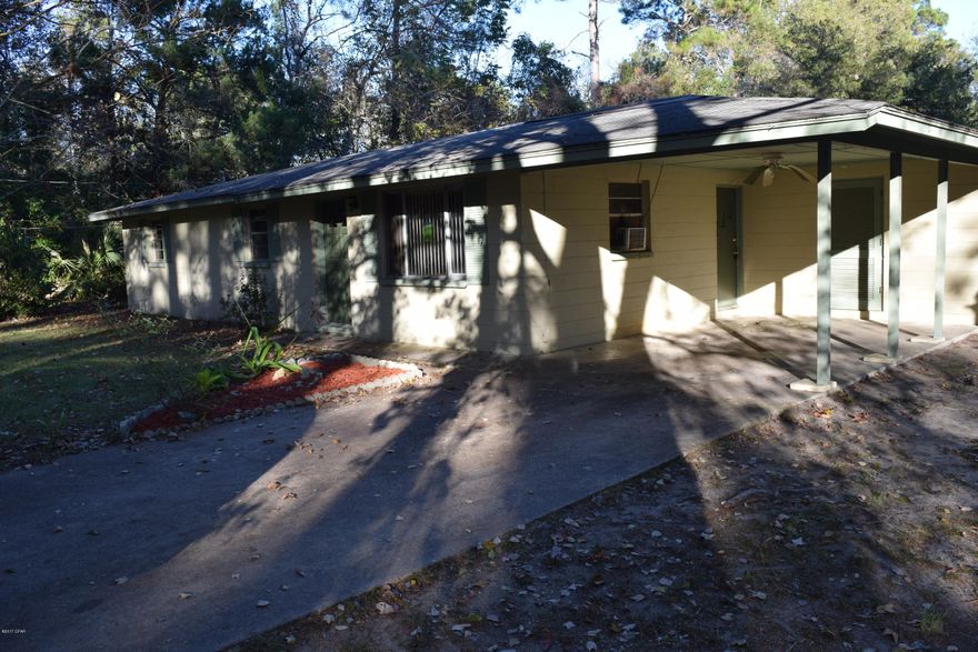 Situated on over an acre of land, this traditional ranch home has 3 bedrooms and 2 bathrooms. The sturdy concrete block house has an attached carport and a drive in yard building. The good sized eat-in kitchen opens out to the amazing yard. Surrounded by a chain link fence and large trees, this homestead is very private. Located on a dead end street, you will love this quiet neighborhood.