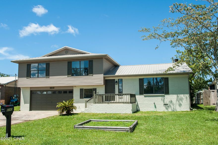 Totally remodeled and ready for you to call home!  Close to Tyndall in a wonderful neighborhood close to the water.  New metal roof, HVAC, cabinets, granite countertops, stainless steel appliances, flooring, paint, lighting, and more.  Living areas are all several feet above ground level, ensuring that the house stays high and dry, and sits on a nice large lot! A great looking home~!  Downstairs you have a large den with a corner fireplace, a totally new kitchen, a powder room, and a breakfast area with sliding glass doors that look out over the raised back deck and large partially fenced back yard.  Upstairs you have three large bedrooms and 2 baths.  BOTH upstairs bathrooms have double vanities and lots of counter space, a very nice touch. The master has a large walk in closet plus an oversized closet in the bathroom, offering loads of storage. The garage is MASSIVE, almost 30 feet deep, with a dedicated laundry area with a utility sink, another dedicated storage area, and a large work area off to one side.  You won't run out of storage space here! To top it all off, the house has a whole house generator!  No waiting hours or days for power after a storm, you will be cool and comfortable!  This house is move in ready, so don't delay!