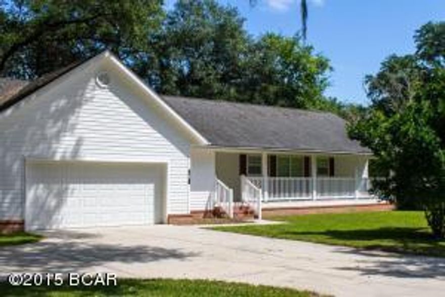 Country Living at its Best!  This wonderful home offers Beautiful views from both the front covered porch and the back screened porch!  You will see the park like setting with water view of the manmade lake from your huge front porch and the view from the back is of Lands lake as the locals know it.  Also, in your front yard you can pick your own fruit from your trees, such as grapefruit, pears, limes, and Kumquats!  This home features a split floor plan and all rooms have generous sized closets.  The Laundry room is very large and has a laundry sink and added cabinets with pull out shelves for storage and a huge pantry area is there for all your goods!  This is a must see!  Call your agent to schedule you showing appointment today, you will be happy you did!!