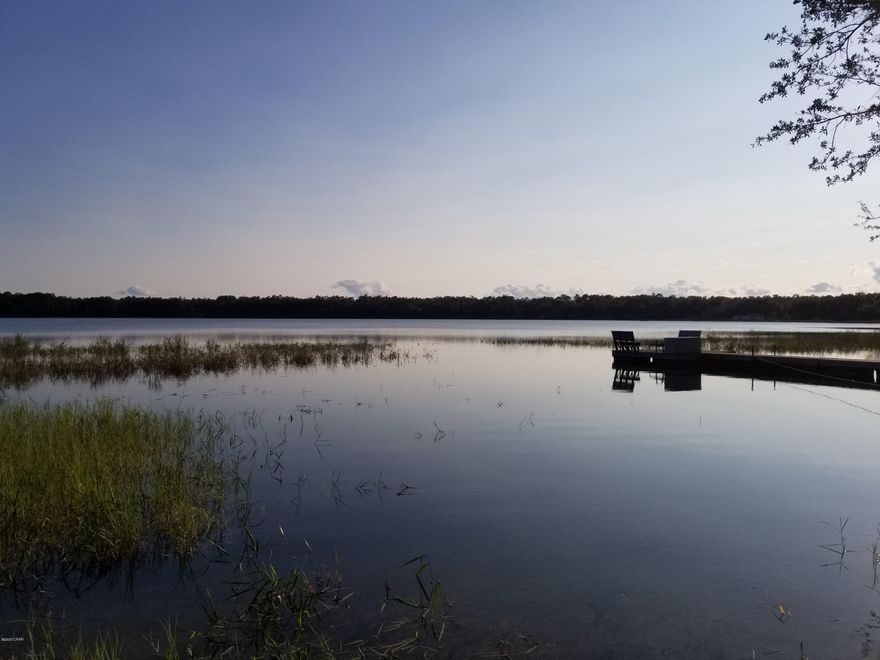 This waterfront lot on the big lake at Leisure Lakes is a great spot to watch the sun go down every evening. The lake is one of the clearest and cleanest lakes in the Florida Panhandle. There are some large oak trees on the property that would be a great place for a permanent residence or a weekend lake house getaway. The lot is about 1 full acre with about 85 feet of sandy beach go enjoy. The community offers a swimming pool, live security gate guards weekdays, covered pavilion with men's and women's restrooms, rental kitchen, exercise room, concrete boat launch, basketball court, tennis court and more. The adjacent lot is also for sale.