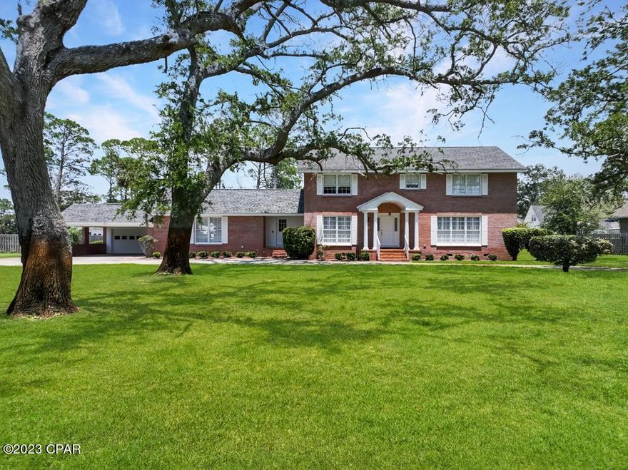 NOSTALGIC BRICK COLONIAL WITH BAY VIEWS IN HISTORIC PORT ST JOE! Reminiscent of the rich familial history of Port St Joe, this charming 5BR/2.5BA home features authentic hardwood floors & original wainscotting. Through the entryway, an inviting foyer opens to a formal dining room adjacent to a large sitting room ideal for entertaining & family gatherings. Modernized with stainless steel appliances & granite countertops, the eat-in kitchen is complete with a walk-in pantry, prep island & stone tiled backsplash. Open to the kitchen is a comfortable living room. Serving as the focal point is a solid masonry fireplace & hearth. Natural light flows through sliding patio doors leading to a grand screened patio overlooking the backyard. Included on the main level is the laundry room, a full bath & bedroom that could easily be turned into an office or study. Upstairs is an oversized primary suite, three additional bedrooms & a full shared bath. An added bonus is a converted storage space with all new LVP flooring perfect for a crafting, a playroom or home schooling. Covered parking along with a two-car attached garage will house all your lawn equipment & beach gear. Near schools, parks and downtown, this stately home is located on a quiet residential street & only steps to bay access. Situated on over a 1/2 acre lot, overtime this beautiful landscape has produced enduring curb appeal with mature shade trees, a lush green lawn & a circular driveway. Fenced in for privacy, the backyard patio is well suited for a BBQ grill & flower gardens with enough room to add a private pool. Teeming with wildlife, the Forgotten Coast is a favorite destination for fishing & boating activities with popular amenities like the newly restored Marina, community boat ramp & fine dining. Filled with charm and character, the timeless aesthetics and architecture of this home offer a sense of history that is classic Port St Joe. Seeing is believing. Take the 3D tour & call for a showing today!