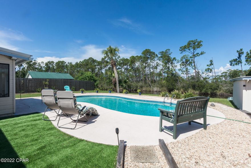 CURRENTLY UNDER CONTRACT, SELLER WILL CONSIDER BACKUP OFFERS. Lynn Haven pool home on 1/2 acre lot! Living area features a wood burning fireplace, enclosed rear patio with pool views, and spacious den with Bayou views. Large kitchen area with eat-in dining and added storage. The master features a large closet space, bath with granite dual vanity, and a private patio near the pool. An additional family/bonus room could also be used for guests, hobbies, or storage. Updates include painted exterior, air conditioning, painted pool deck, pool accent tile, garage roof, sliding glass doors, and more! 2 Stall detached garage also features a finished room, and a yard building with workspace and storage for your outdoor tools, toys, and more. Virtual Tour Available!