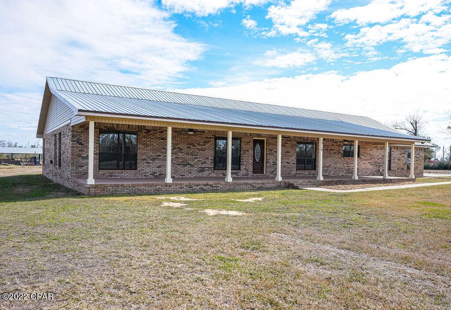 Country CHARM with all of the conveniences of living in the city. This completely renovated 4 bedroom 3 bath home sits on one acre in the country yet only minutes from Panama City.  The interior boasts a  fresh and clean HUGE kitchen with down draft cook top, built in oven and loads of cabinet space. You have to look at the pictures!!  The dining area adjoins the kitchen making it a massive room.  The great room is focused around a wood buring fireplace and vaulted ceilings. Another living room adds even more space.  With 4 bedrooms (all very large) there is room to roam.  The master has a custom corner shower and jetted tub big enough for two.  One of the bedrooms has its own bathroom AND a door leading to the outside, perfect for guests or a home based business.  Flooring is brand new throughout the home, the paint is fresh and everything is new.  An oversized two car garage is attached AND a separate 32x24 enclosed barn is a bonus to those that need the room!  The front porch is the perfect place to sit and relax and the back screened in patio adds even more livable space.   This home has a metal roof and brick exterior easy maintenace!  There is a possibility of the neighbors selling the extra acreage around the home. Call Your Realtor today