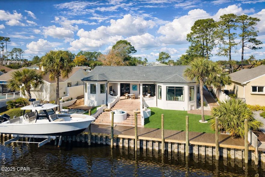 Experience the pinnacle of waterfront living in this exquisitely refreshed 3-bedroom, 2.5-bath residence offering 3,268 square feet in the prestigious Bay Point community. Perfectly positioned for boating enthusiasts, this home features a private dock and 16,000 lb boat lift with direct access to North Lagoon and the Gulf of Mexico, complemented by extensive recent dock upgrades including new pilings, a new dock surface, and an entirely rebuilt sub-structure finished with high-grade composite materials.

Enter into an impressive open floor plan flooded with sunlight, where expansive floor-to-ceiling windows capture panoramic water vistas. The elegant living space showcases custom shiplap accent walls, a contemporary fireplace, and high-end coastal design elements throughout.

The gourmet kitchen is ideal for entertaining, featuring top-of-the-line stainless steel appliances, an oversized quartz island, custom cabinetry, and an adjacent wine bar with glass shelving and striking blue accents.

The primary suite serves as a private waterfront retreat with tranquil water views, direct outdoor access, and a spa-like en-suite bath complete with dual vanities, a soaking tub, and custom cabinetry. Two additional generously sized bedrooms share a beautifully updated second bathroom.

Outdoor living truly shines with an expansive waterfront entertaining area featuring a fountain and pavered area for a firepit, ideal for sunset gatherings or peaceful evenings by the water. The property has been completely transformed with a full landscape package, including 16 tons of Bahama rock, over 130 plants and bushes, multiple truckloads of fresh mulch, a brand-new irrigation system, and 32 new landscape lights. All fountain and wall lighting has been rewired for proper function, creating a dramatic nighttime ambiance.

Additional upgrades include an epoxied garage floor and an impressive circular driveway offering excellent curb appeal and ample parking.

Combining luxury, comfort, and an unmatched waterfront lifestyle, this meticulously upgraded home offers the best of coastal living. Don't miss the opportunity to make 443 Wahoo Road your own private paradise.
