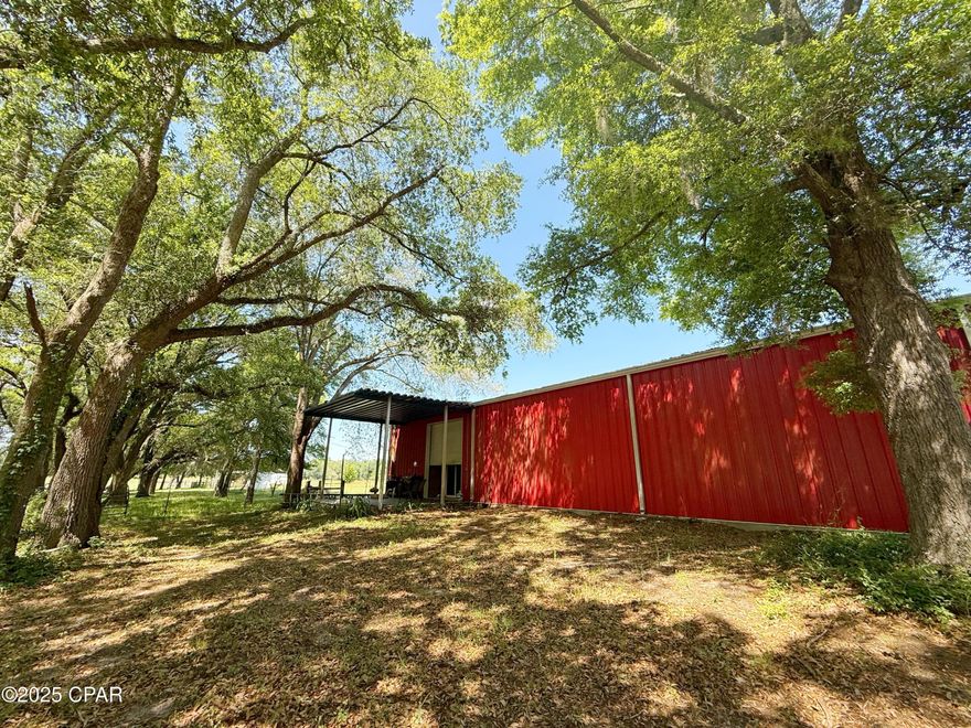 Rustic Luxury Meets Modern Comfort on 37 Scenic Acres

Welcome to your dream retreat — a beautifully designed barndominium nestled among the serene beauty of a mature oak grove. This unique home features an extra-large bedroom and a spacious, handicapped-accessible bathroom, thoughtfully equipped with a roll-in shower, walk-in tub, and dual vanities, providing both comfort and functionality.

The open-concept living space boasts a large kitchen outfitted with upgraded stainless steel appliances, generous counter space, and a pantry, perfect for entertaining or everyday living. Step outside onto the covered porch and enjoy peaceful views of the surrounding oak trees — a perfect spot for your morning coffee or evening unwind.

Built with durability in mind, the home includes roll-down storm shutters for exterior door protection, propane tanks, and an on-demand Rinnai water heater for continuous hot water.

Connected to the main living space is an enclosed barn featuring two roll-up doors and laundry hookups — ideal for storage, workspace, or livestock needs. Just steps away, a Quonset hut-style airplane hangar offers additional covered storage for equipment, vehicles, or projects.

This fully fenced and gated 37-acre property is thoughtfully divided into four pastures, each with water and electric available, making it ready for livestock or farming. A pole barn with lean-tos on both sides, also equipped with electricity and water, adds even more functionality and value. With road frontage on two county-maintained paved roads, access is convenient from multiple directions.

Cow panels do not convey. Most of the land is cleared and prepped, offering a turnkey opportunity for agricultural use, hobby farming, or simply enjoying wide open space in style.