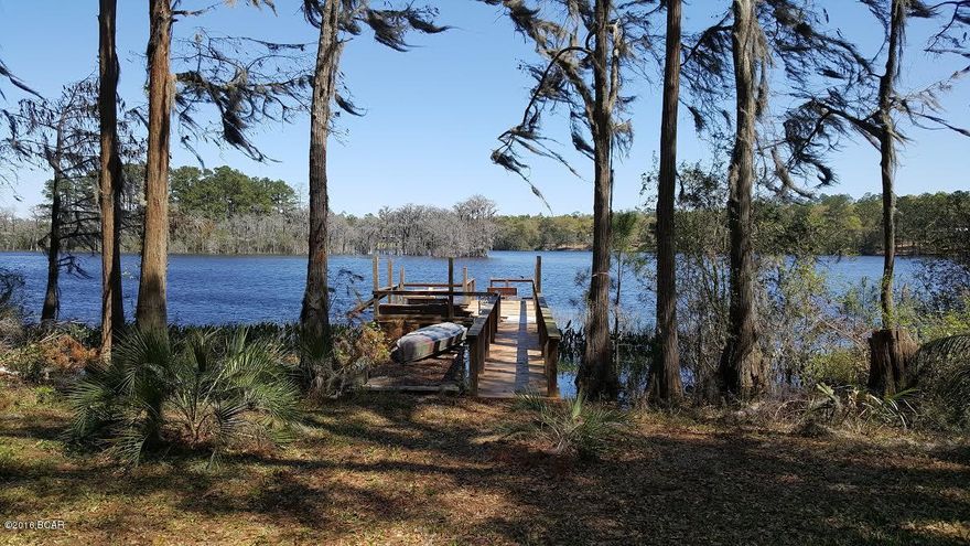 Beautiful Lakefront lot- This 1.7 acre lot is mostly cleared, with a gentle slope towards spring fed Dunford Lake. There is a 25'x40' metal building with insulation and concrete flooring. Small screened in area to enjoy the view or walk out on the 45' dock to fish for Bass, Bluegill, Crappie or have a picnic lunch on the deck. Up to 25 HP engines and maximum 15 mph on lake. No association fees and there is a community boat ramp within walking distance. Approx. 35 miles from Panama City Beach, Pier Park shopping and airport. Must see this view!