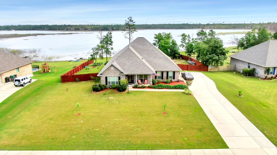 'CURRENTLY UNDER CONTRACT, SELLER ACCEPTING BACKUP OFFERS'-Highly desired Lake Merial community-Incredible spring fed lake front home with remarkable views and cared for meticulously! Home features: 5 bedrooms, 3 bathrooms, with an additional room (which could either be a formal living room or office). This home has an open concept from the kitchen and breakfast area through to the family room. It also boasts high tray ceilings, designer cabinets, granite counter tops, updated fixtures, ceramic tile flooring in kitchen and bathrooms and bamboo flooring through remainder of home. You won't find any carpet in this home! Always have hot water on demand with the high end tankless water heater by Navien. Once outside, the possibilities are endless. Enjoy shade under the covered porch or take a dip in the refreshing saltwater pool (designed and installed by Cox Pools: 32'x16') that includes a 4' bench in the 6' deep end of the pool. The screened in pool enclosure measures 30'x55'x26' (Gable Hip) and will keep those summer mosquitoes away.  Stay cool in the pool relaxing on the dedicated tanning shelf that holds an umbrella IN the water. Soak up the sun while you lounge on the oversized kretekoted deck. Relish in the summer days while enjoying "lake life" fishing off of the floating boat dock then clean your fresh catch at the fish cleaning station with running water. For the gardeners, you will find various fruit trees and raised beds which will give endless opportunity to plant and grow your own fresh fruits and vegetables so you can live off the land. Irrigate the 3/4 acre lot with RainBird well irrigation. Secure your outdoor toys and tools with the 10'x16' storage shed (new in 2017). Other additions include the expanded driveway which adds 5.5' to the width for additional parking. This is the ideal home to build memories to last a lifetime. 
*Boats, hot tub outside and walk-in tub do not convey in the sale of the property*