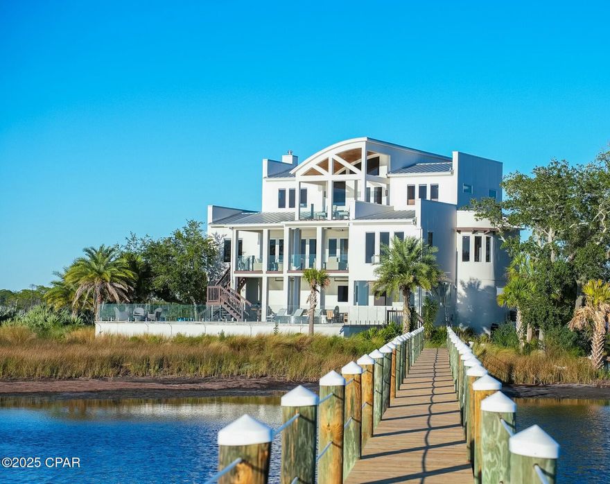 Discover unparalleled luxury on a private island in northwest Florida, where contemporary architecture meets serene tropical beauty. This extraordinary masterpiece was recently featured on HGTV House Hunters Amazing Water Homes in January 2025 and is even more stunning in person than on international TV! 

As you approach Northshore Islands, you're greeted by only a few homes and this home exudes privacy, exclusivity and remarkable architecture. Built by Rita Jones with the design team of Architect Michael Hunnicutt, and Katie Fisher Design, Interior Design, this exceptional three-story contemporary, modern estate spans over 5,000 square feet, offered fully furnished with NEW furnishings and offers breathtaking waterfront views from every room. Enjoy expansive outdoor living with bay-view covered porches on each level, perfect for soaking in the tranquility of the surroundings on the island.

Imagine leaving your dock for Shell Island or heading out for a sunset cruise. Picture yourself with the kids by the pool while watching the sun sink into the horizon. This is one of the very few locations in Panama City, Florida that has been built based on the picturesque views and was designed to maximize views of the water from all angles. This private island is a truly a waterfront dream come true!

For boating and fishing enthusiasts, the property features a private, recently renovated, 350' dock with deep water access to the Gulf of Mexico, which is just 10 nautical miles away with no idle speeds zone in between, offering endless opportunities for fishing and adventure. The dock also holds a 2021 Barletta Pontoon boat on lift and a NEW 40,000 LB boat lift, ALL of which will convey to the new owner to be able to enjoy the waterfront lifestyle from day one! Not looking for boating adventure? This home offers zero entry into the Bay which is perfect for kayaks, paddleboards and swimming as you watch the picturesque sunset set in the West each day. The island's natural landscaping and soothing bay sounds welcome you to this peaceful retreat, where indoor and outdoor spaces blend seamlessly with a saltwater pool and spa.

Upon approach to the circular cobblestone paver driveway, you're greeted by sea breezes and a travertine marble tile entry and a foyer framed with a custom Mahogany wood door with artistic blown glass. Entering the main level, the stunning waterfront views stand out as you sit at 23' elevation and enjoy a great room that offers views of the island from all angles. The family room area is framed by custom millwork and a modern linear fireplace surrounded with marble and slate tile creates warmth in the space while framing a wall of full-glass French doors that lead out onto a covered patio overlooking both pool and Bay. From here you can take in gorgeous year-round sunsets as they sink into the horizon each evening. This level also features a light-filled dining room overlooking the natural landscape of the island and a powder room with Onyx walls and custom pedestal sink for guests, and a junior suite overlooking Bay and pool complete with full bath, walk in closet, and Juliet balcony. Luxurious polished travertine tile is consistent throughout the main floor in the great room for a seamless look.

The open kitchen is fully-equipped and features a custom slab walnut cabinetry, 48'' Thermador Professional convection microwave oven, warming drawer, Viking range hood and full-size Electrolux refrigerator and freezer. A Caesarstone Quartz waterfall countertop island is a showpiece and the oversized island seats 4. The bar and new wine refrigerator are excellent for entertaining and just off the kitchen and adjacent to the 16'x10' walk-in pantry and laundry room with stunning granite countertops, custom cabinetry, washer and dryer and the most perfect views of the island! The primary suite, just off the kitchen, is a haven of luxury, offering radiant heated Italian porcelain tile floors, a spa-like Grohe walk-in shower with 3 body jets and 2 hand showers, new freestanding tub overlooking the Bay, slab walnut cabinetry with Swarovski crystal knobs and direct access to a waterfront patio with a fireplace. This retreat also features a large 14'x9' closet in the primary suite featuring fully enclosed cabinetry. 

The lower level outdoor summer kitchen is an entertainer's dream, overlooking the Bay and pool, is equipped with new luxury appliances, Caesarstone quartz countertops, and custom walnut cabinetry. The pool is framed with luxurious custom tile, Travertine decking and offers new equipment for easy maintenance. With an 18' deep covered patio, your entertaining dreams will become a reality in this world-class outdoor living area. Overlooking the Bay, your boat and the best sunsets that Panama City has to offer - you can't wait to call this one home.

The third level provides a 19"x16" loft living area with remarkable barreled tongue and groove ceiling, waterfront office filled with floor to ceiling glass and doors, and two en suite guest bedrooms, each with walk-in closets and recently renovated luxurious private en suite bathrooms with marble and custom tile finishes.  

The lower level includes a 35"x24" 4-car tandem garage, 15"x10" workshop space, media-game room with full kitchenette, full bathroom and a walk-in wine room, ideal for entertaining being just off the outdoor summer kitchen and pool area. 

The home's robust construction features cement-filled concrete block walls, hurricane-rated Anderson windows, 150-mph wind rated garage doors, safe room and a 1/2" tempered, frameless glass railing system for unobstructed Bay views. A built-in generator fully powers the second and third floors of the home and there are high-efficiency heat pumps for each floor providing comfort and convenience. A solid, standing seam aluminum roof was installed in 2019. The home has a 500-gallon underground propane tank and infrastructure on the island includes high speed internet, city water and sewer. 

This exclusive waterfront home offers a rare opportunity to live the coastal life you've always desired.