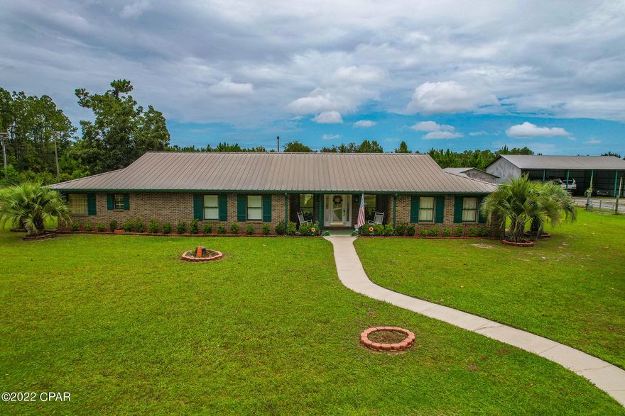 Beautiful and spacious red brick home in a great location on 2.2 acres.  The kitchen is a chef's dream with stainless steel appliances to include a Kenmore Elite refrigerator, stove, separate oven, dishwasher and microwave.  Deluxe kitchen island has a new cooktop and an attached breakfast bar.  The master suite features a huge bedroom with large walk-in closet and a bathroom with garden tub and double vanities. Cozy living room with a fireplace and plenty of room for the whole family. Large laundry room with tile countertops and built-in cabinets.  Home has beautiful hardwood pecan floors, ash floors, and juniper walls throughout.  There is a detached 40x51 metal building, a pole barn, and a 5-stable barn including a tack room. The entire property is 4' chain link fence. The pole barn and metal shop is separated by a chain link cross fence along with an automatic gate.  There are currently 3 renters at the workshop and pole barn - one business renter, one rv, and one boat -and renters do wish to remain, if buyer allows.  Bring your horses and enjoy this country living !!  Only 30 minutes drive to the pristine sugar sand beaches and 15 minutes to the International (ECP) Airport.