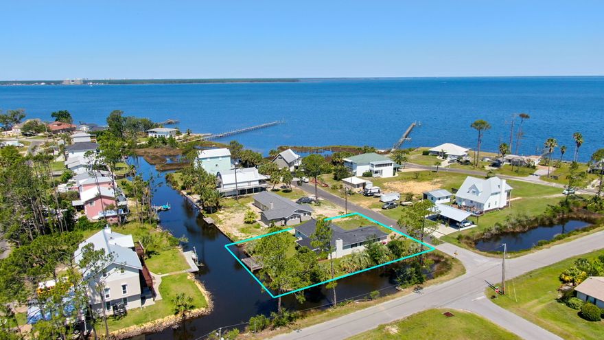 FURNISHED WATERFRONT HOUSE WITH DOCK UNDER $300,000!  The interior of this home features 3 bedrooms, 2 full baths, an open floor plan, a new kitchen, new vinyl plank floors (no carpet), fresh interior paint, ample natural light, an interior laundry room, a security system with cameras, and a 2 car garage.  The brand new kitchen features granite counter tops, stainless steel appliances, a breakfast bar and an XL 7x6 pantry.  The living room has a wood burning fireplace and looks out toward the water.  The bedrooms are good size.  Enjoy the outside while sitting inside your 20x12 screened porch! The exterior features a 130x130 lot with 2 sides canal front (survey available), a seawall and dock, fresh exterior paint, an extra parking pad for boat parking, and a sprinkler system with private well for irrigation.  NEW WITHIN THE PAST 5 YEARS:  Roof, Seawall, Dock, Septic System, Security System, Floors, Kitchen, Trim, Gutters, Well Pump, and Furniture.  Call today for your own private preview.