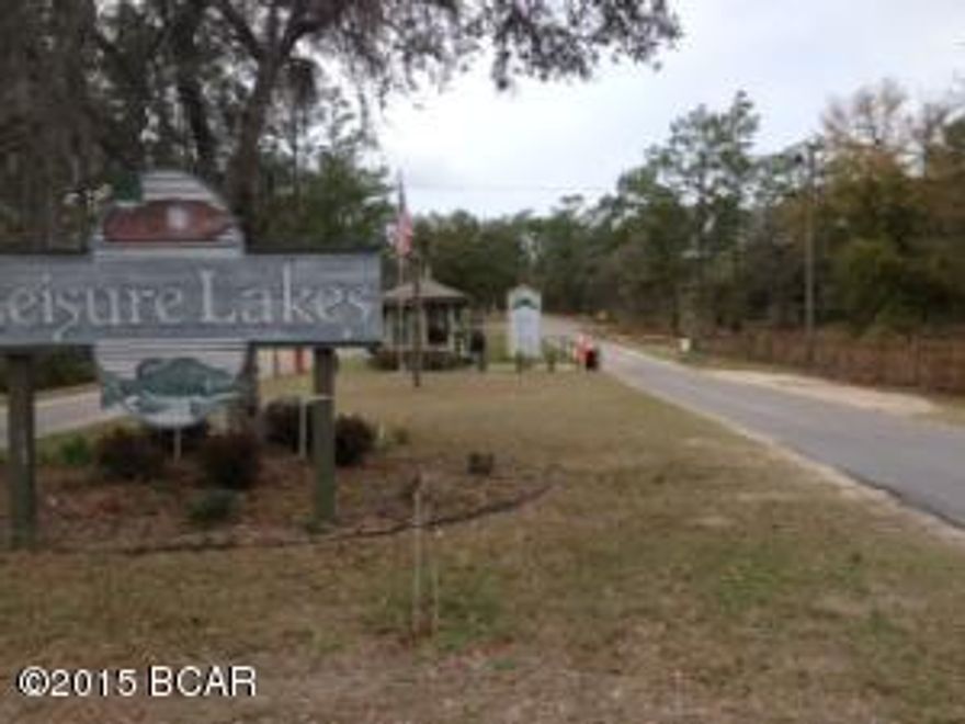 This is affordable waterfront property in a security gated community that offers plenty of recreation for all ages. This 1-acre wooded lot slopes down to the smaller of the two lakes inside the subdivision, and has a boat launch for those who want to fish or cruise the lake in a boat or kayak. Other recreation is available at the covered pavilion that includes a swimming pool, basketball court, tennis court, an exercise room, grilling stations, beach swimming area, floating dock, and a second boat launch. A rental full kitchen is available for special occasions. Security personnel man the guard shack during weekdays, residents have a personal code to enter the gates when personnel are off duty. HOA dues are only $250 per year.